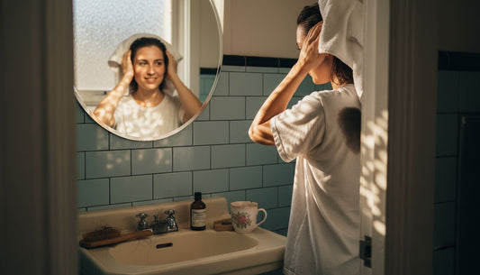 Woman drying hair at home bathroom window
